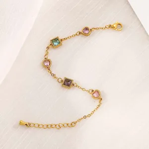 Dettaglio del bracciale in acciaio dorato con pietre di zircone colorate a cuore