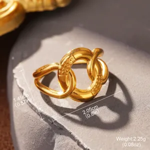 Detailaufnahme eines goldenen Titanstahlrings mit ovalem Design auf einem Stein.