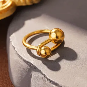 Makroaufnahme eines gold polierten Titanstahl-Ringes mit zwei Kugelenden.