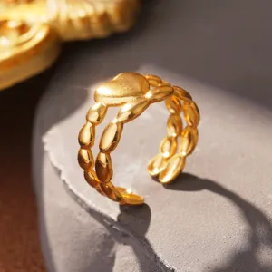 Makroansicht der goldenen Herzring-Details mit eleganten ovalen Blattmustern am Band