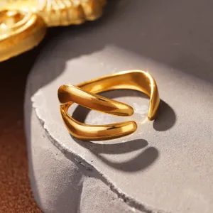 Detailaufnahme eines minimalistischen goldenen Wellenrings aus poliertem Titanstahl