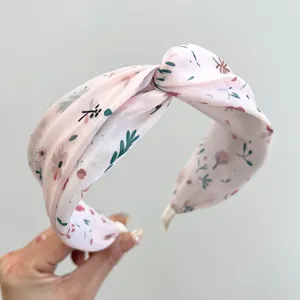 Close-up of pink floral twisted wide headband with delicate flower pattern
