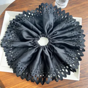 Vue détaillée du chouchou géant en tissu plissé noir avec des motifs découpés au laser précis.