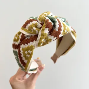 Detailansicht eines bunten, gewebten Stirnbands im Ethno-Stil mit geometrischem Knoten-Design.