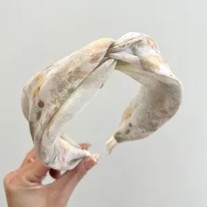 Detail view of elegant New Chinese style floral knotted headband with satin texture