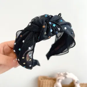 Gedetailleerde weergave van zwarte mesh haarband met kleurrijke strass steentjes