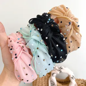 Detailweergave van geknoopte mesh haarbanden met sprankelende strass in diverse kleuren.