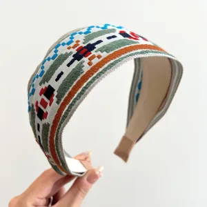 Nahaufnahme eines ethnischen breiten Haarreifens mit buntem geometrischem Stickmuster.