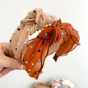 Detailopname van mesh hoofdbanden met kleurrijke strass-steentjes en knoop