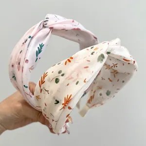 Detail of floral printed cross-knot headbands in pink and cream with silky smooth texture