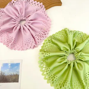 Gros plan sur des chouchous plissés géants roses et verts avec un superbe design ajouré