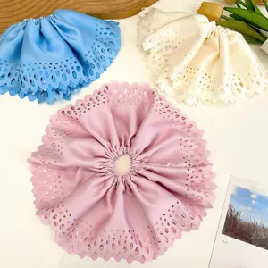 Vue détaillée de chouchous surdimensionnés découpés au laser en rose, crème et bleu