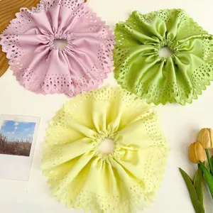 Gros plan sur des chouchous plissés évidés surdimensionnés en rose, vert et jaune