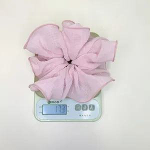 Vista detallada de un coletero rosa con textura que pesa 17,3 gramos en una báscula electrónica