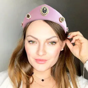 Primo piano di un'elegante fascia rosa con perle e raffinati ornamenti vintage su una modella