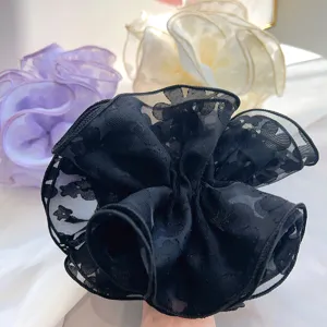 Close-up detail of elegant double-layer lace scrunchies in black, purple and beige colors