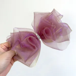 Détail d'un grand nœud pour cheveux en organza dégradé violet avec centre en strass