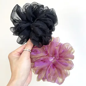 Détail de grands chouchous en organza noir et dégradé rose pour les cheveux fins