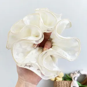 Detailed close-up of a premium white double-layer floral lace scrunchie hair tie