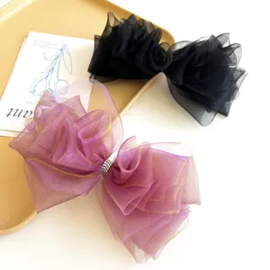 Zoom sur des barrettes à cheveux élégantes avec nœuds en organza dégradé violet