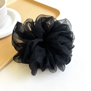 Gros plan détaillé d'un chouchou géant en organza noir élégant montrant la texture du tissu