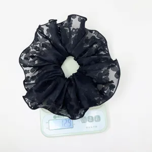 Detailed view of black lace floral hair scrunchie weighing 12.9 oz on electronic scale