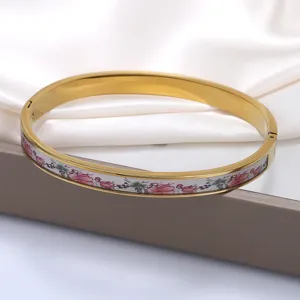Nahaufnahme eines Retro-Emaille-Blumenmusters auf einem 18K vergoldeten Titanstahl-Armreif.