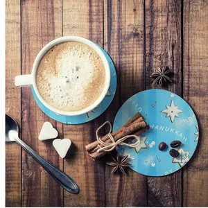 Close-up detail of blue DIY Hanukkah sublimation coaster on wooden table with coffee.