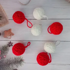 Gomitoli di lana rossi e bianchi fatti a mano per decorazioni natalizie e fai da te festivo