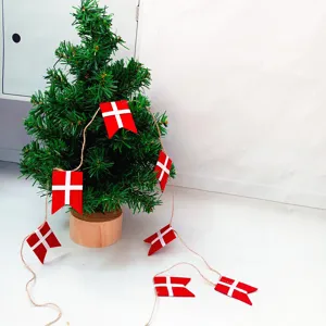 Dettaglio della ghirlanda con bandiere danesi rosse e bianche su un mini albero di Natale.