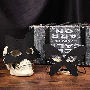 Detailed view of black felt Halloween masks in cat and butterfly shapes on skull props.