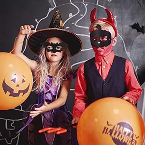 Children wearing bat and pumpkin Halloween felt masks at a festive party scene.