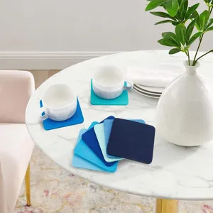 Verschiedene blaue quadratische Filz-Untersetzer auf einem weißen Marmortisch