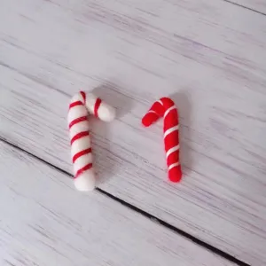 Close-up of handmade red and white wool felt candy canes for Christmas tree decoration
