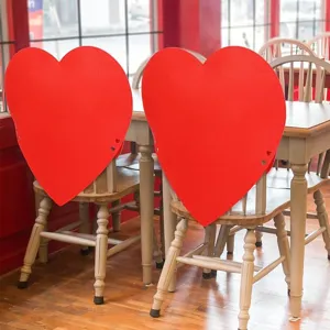 Fundas de fieltro rojo con forma de corazón para sillas en decoro de San Valentín