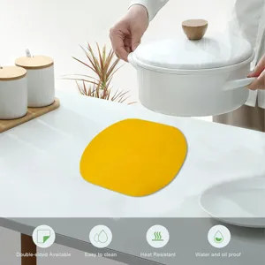 Detail view of a yellow heat resistant felt placemat used under a white pot.