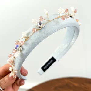 Gedetailleerd zicht op een lichtblauwe hoofdband met roze parels en kristallen