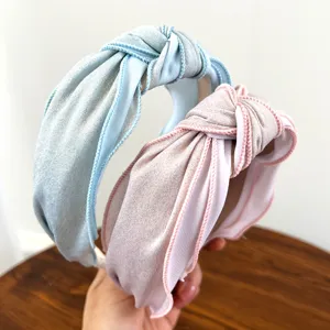 Detailopname van glinsterende geknoopte stoffen haarbanden in pastel blauw en roze