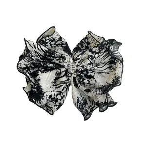 Stylish black and white tie-dye bow hair clip with sparkling rhinestone center detail.