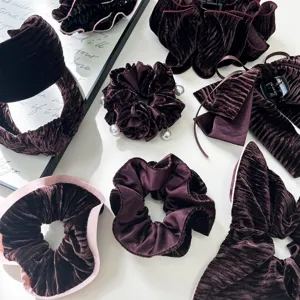 Detailed macro view of elegant burgundy velvet scrunchies and headbands