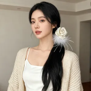 Close-up of model wearing an elegant white camellia hair scrunchie with soft ostrich feathers
