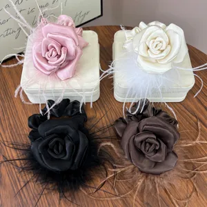 Detail showing the satin rose petals and delicate ostrich feathers of handmade scrunchies
