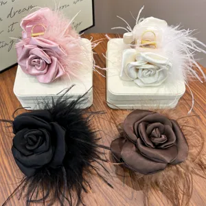 Detail showing handmade silk rose hair clips with soft ostrich feathers in four elegant colors