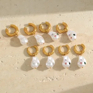 Detail view of baroque pearl hoop earrings with colorful rhinestones on stone background