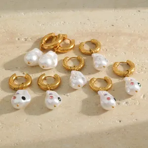 Detailed view of baroque pearl earrings with colorful rhinestones in gold finish.