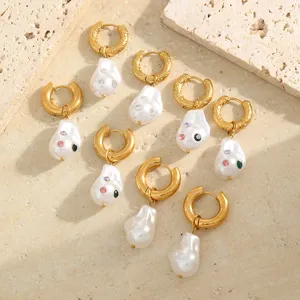 Macro view of Baroque pearl earrings with sparkling multi-color rhinestones on gold hoops
