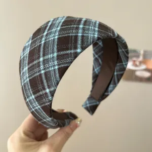 Nahaufnahme des französischen Retro-Haarbandes mit elegantem blau-braunem Karomuster