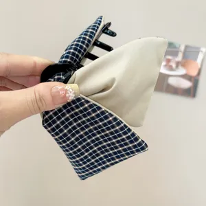 Detailed view of the plaid and beige fabric stitching on the bow hair claw clip