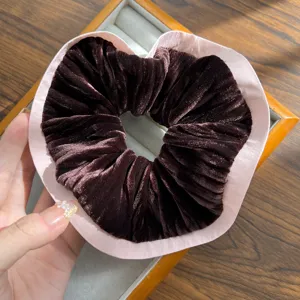 Detail view of heart-shaped retro velvet scrunchie featuring an elegant pink satin border
