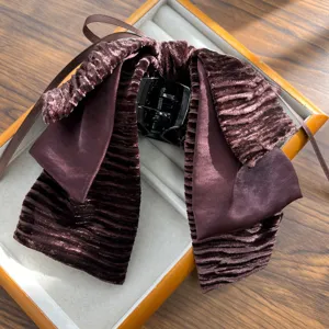 Detailed macro of a retro deep purple velvet bow hair clip with pleated texture